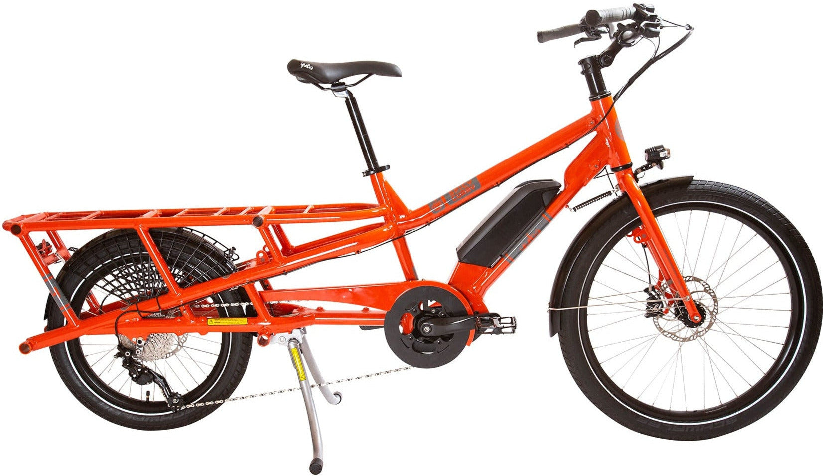A blue Yuba Spicy-Curry V3 electric cargo bike with a step-through frame and two wheels, designed for carrying cargo or passengers.